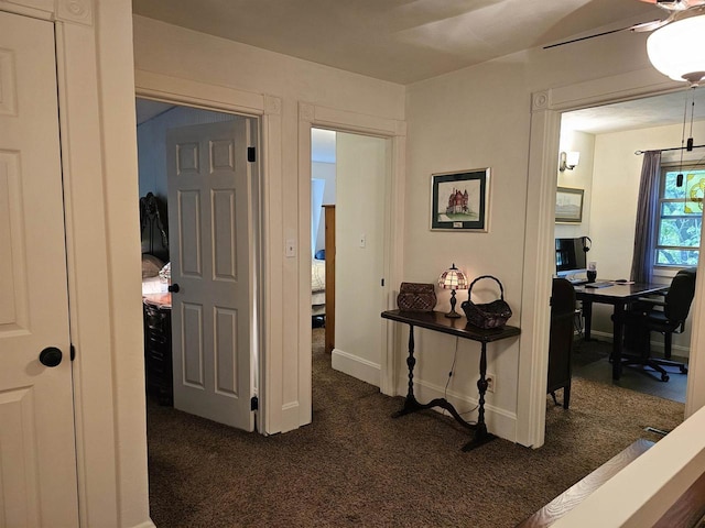 9388 Alpine Rd, Fremont, WI 54940 - hall with dark colored carpet, a desk, and baseboards
