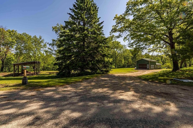 17785 Circle Dr, Boscobel, WI 53805 - view of green lawn with a garage, an outdoor structure, and dirt driveway