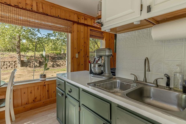 17785 Circle Dr, Boscobel, WI 53805 - kitchen with a sink, wooden walls, light countertops, green cabinetry, and light wood finished floors