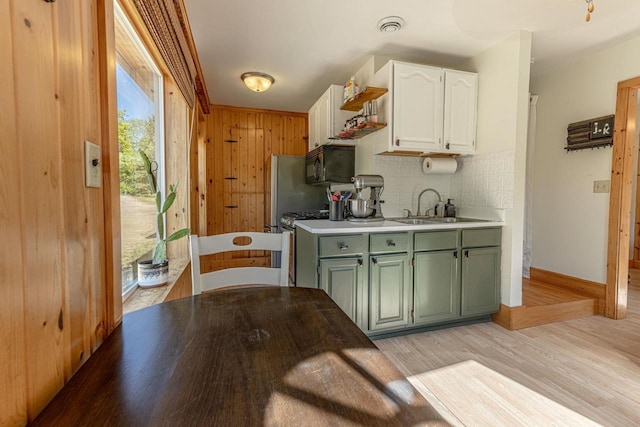 17785 Circle Dr, Boscobel, WI 53805 - kitchen with black microwave, white cabinets, a sink, decorative backsplash, and light wood finished floors