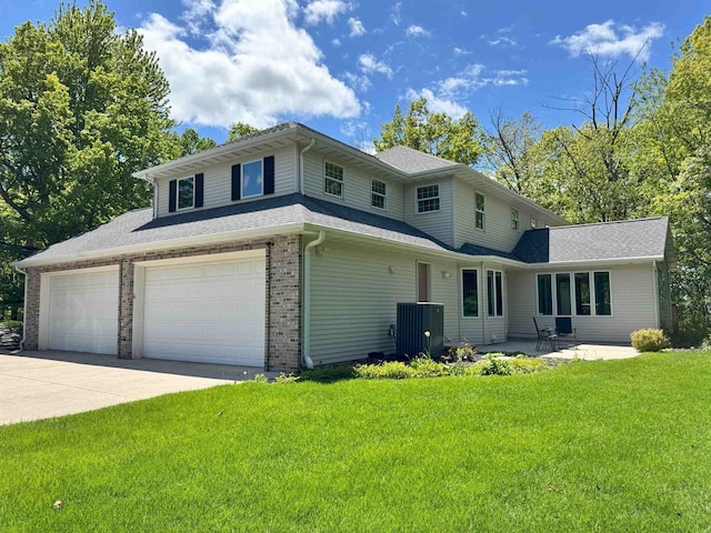 79 Oakridge Ct, Fond Du Lac, WI 54937 - view of front of house with a front lawn, central AC unit, concrete driveway, brick siding, and a garage