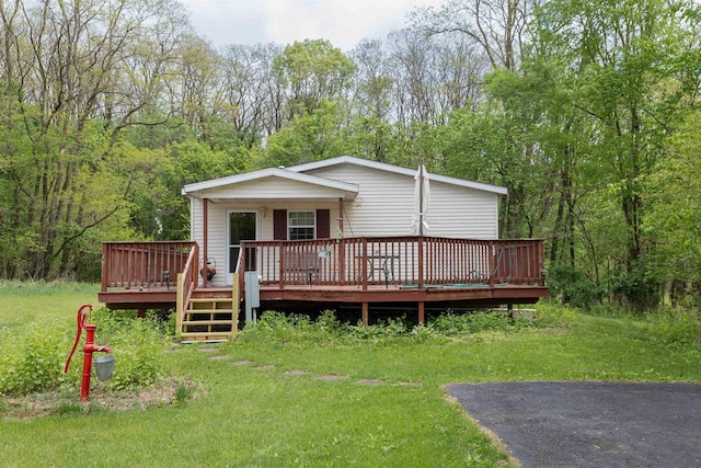 W7744 County Rd E, Westfield, WI 53964 - view of front of property with a wooden deck, a forest view, and a front lawn