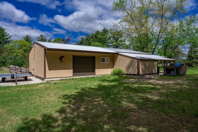 N12124 12th Ave, Necedah, WI 54646 - back of house with a garage, an outdoor structure, metal roof, and a yard