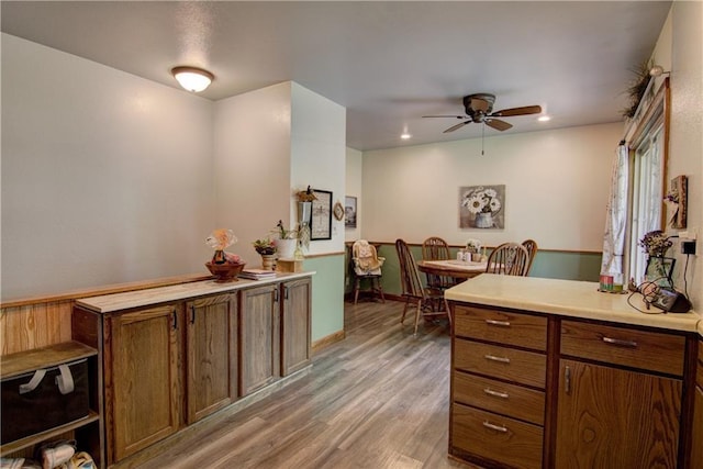 739 Veronica St, Chippewa Falls, WI 54729 - kitchen featuring ceiling fan, light wood finished floors, light countertops, brown cabinetry, and a peninsula