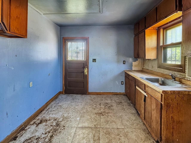 6913 W Main St, Milwaukee, WI 53214 - kitchen with a sink, baseboards, light countertops, and tasteful backsplash