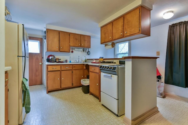 1427 Madison Ave, South Milwaukee, WI 53172 - kitchen featuring white appliances, brown cabinets, and plenty of natural light