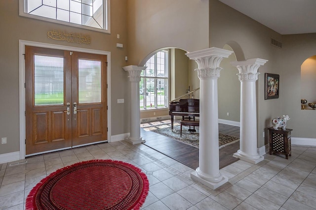 18290 Prairie Falcon Ln, Brookfield, WI 53045 - foyer with decorative columns, baseboards, light tile patterned flooring, arched walkways, and french doors