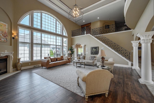 18290 Prairie Falcon Ln, Brookfield, WI 53045 - living room featuring a towering ceiling, healthy amount of natural light, dark wood-style flooring, stairway, and a high end fireplace