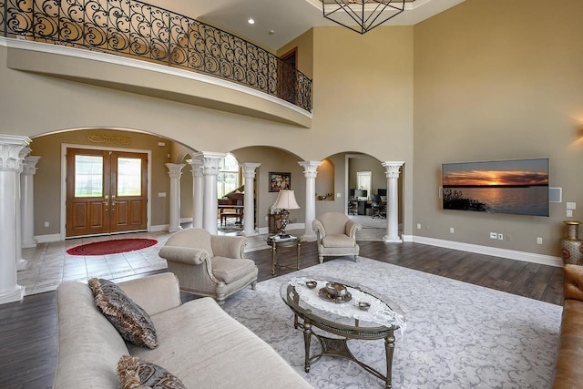 18290 Prairie Falcon Ln, Brookfield, WI 53045 - living area with ornate columns, arched walkways, a towering ceiling, baseboards, and wood finished floors