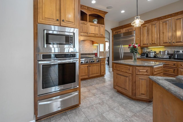 18290 Prairie Falcon Ln, Brookfield, WI 53045 - kitchen with a warming drawer, built in appliances, tasteful backsplash, brown cabinetry, and recessed lighting