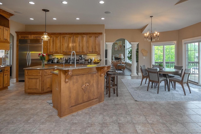 18290 Prairie Falcon Ln, Brookfield, WI 53045 - kitchen with ornate columns, built in fridge, a kitchen island, brown cabinetry, and recessed lighting