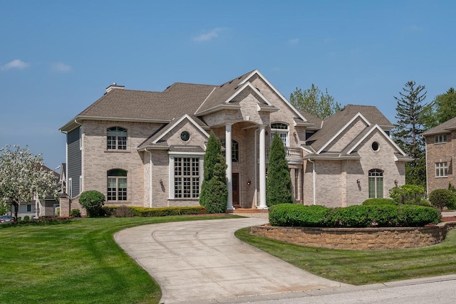 18290 Prairie Falcon Ln, Brookfield, WI 53045 - view of front facade featuring brick siding, a front lawn, curved driveway, and roof with shingles