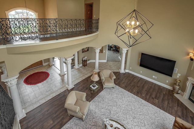 18290 Prairie Falcon Ln, Brookfield, WI 53045 - living area featuring ornate columns, arched walkways, wood finished floors, a high ceiling, and stairway