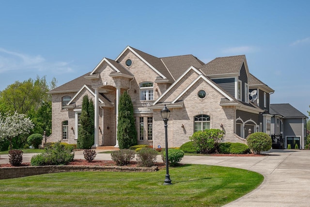 18290 Prairie Falcon Ln, Brookfield, WI 53045 - french country home with brick siding, a front lawn, and curved driveway