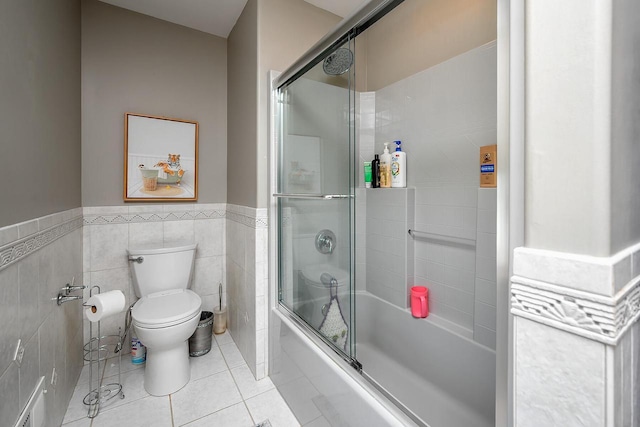 18290 Prairie Falcon Ln, Brookfield, WI 53045 - bathroom featuring tile patterned floors, shower / bath combination with glass door, toilet, wainscoting, and tile walls