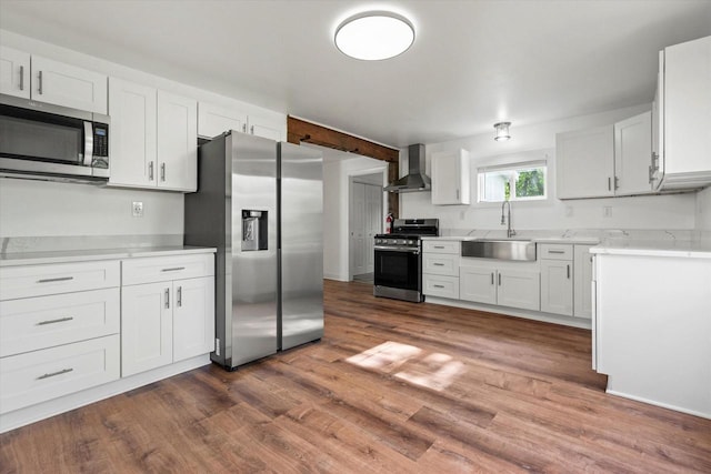 10104 Washington Ave, Mount Pleasant, WI 53177 - kitchen featuring stainless steel appliances, a sink, wall chimney exhaust hood, dark wood finished floors, and white cabinetry