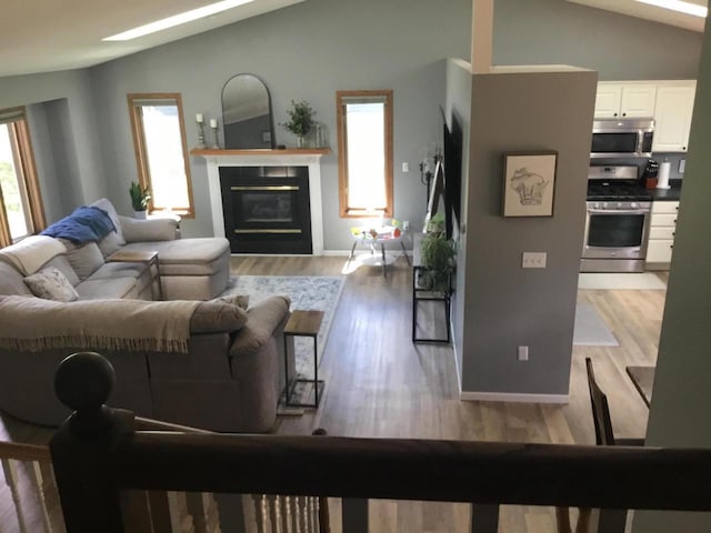 2706 Pleasant Dr, Holmen, WI 54636 - living room featuring vaulted ceiling, a glass covered fireplace, and light wood-style floors