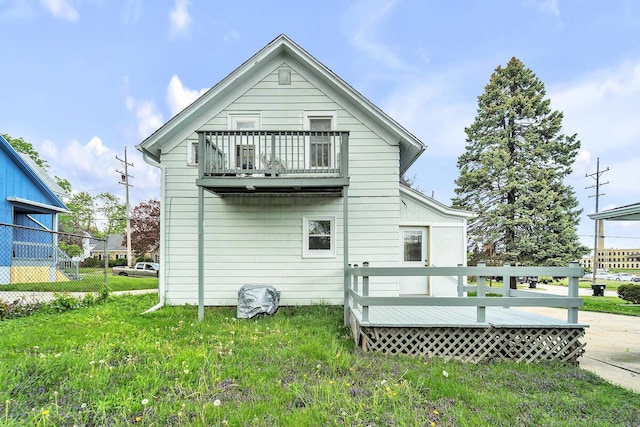 2301 W High St, Racine, WI 53404 - back of property featuring a balcony, a wooden deck, and a lawn