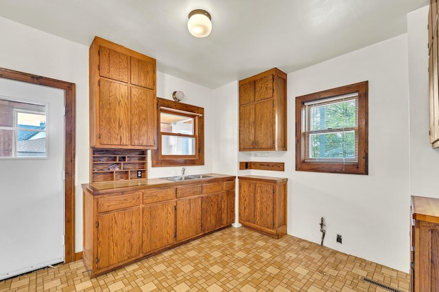 2301 W High St, Racine, WI 53404 - kitchen with a sink, brown cabinetry, and light countertops