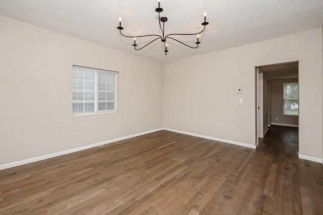 301 Maple Ave, Clinton, WI 53525 - spare room with a chandelier, wood finished floors, and baseboards