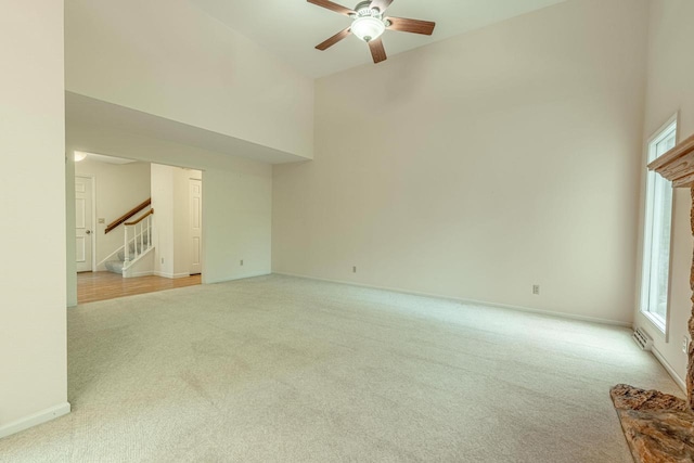 1 Winterberry Trl, Madison, WI 53717 - empty room featuring carpet floors, ceiling fan, stairs, plenty of natural light, and a high ceiling