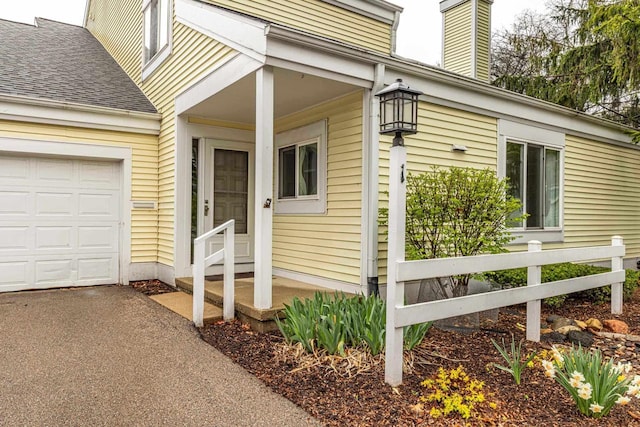 1 Winterberry Trl, Madison, WI 53717 - doorway to property featuring roof with shingles, a chimney, asphalt driveway, and a garage