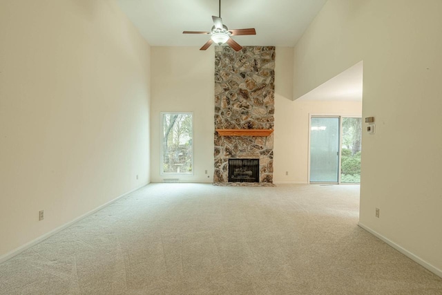 1 Winterberry Trl, Madison, WI 53717 - unfurnished living room with healthy amount of natural light, a ceiling fan, a stone fireplace, carpet floors, and high vaulted ceiling