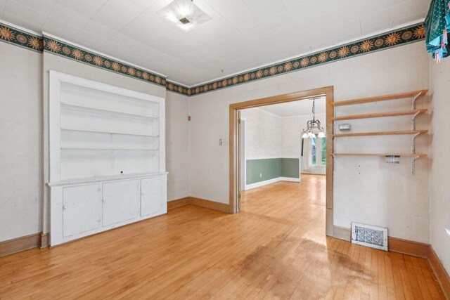 1525 N 69th St, Wauwatosa, WI 53213 - empty room featuring a chandelier, light wood-style flooring, and baseboards