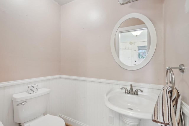 1525 N 69th St, Wauwatosa, WI 53213 - half bath featuring wainscoting, toilet, and a sink