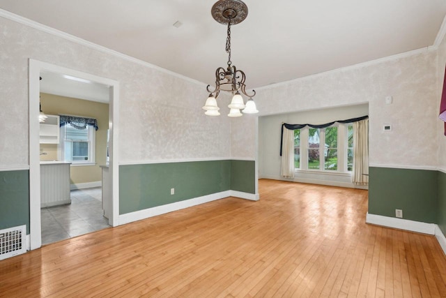 1525 N 69th St, Wauwatosa, WI 53213 - empty room featuring a chandelier, hardwood / wood-style floors, crown molding, healthy amount of natural light, and baseboards