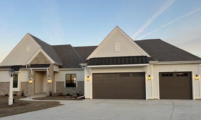 1600 Sauk Trl, Waukesha, WI 53189 - view of front of home featuring a garage, concrete driveway, a standing seam roof, and metal roof