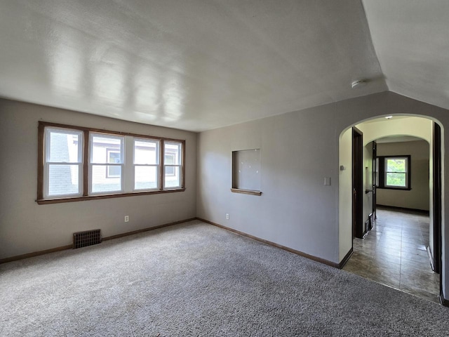 2931 N 58th St, Milwaukee, WI 53210 - carpeted spare room with arched walkways, baseboards, a smoke detector, and lofted ceiling