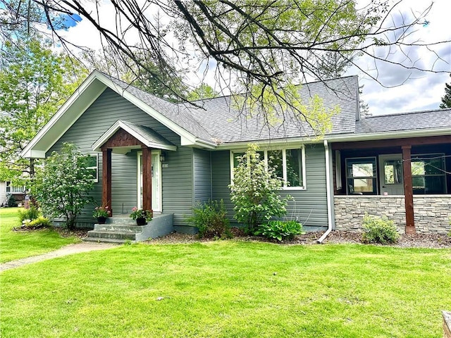 1019 2nd St, Bruce, WI 54819 - view of front facade with a front yard, roof with shingles, and stone siding