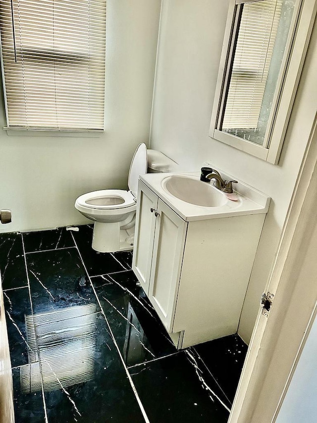 5879 N 29th St, Milwaukee, WI 53209 - half bathroom with marble look tiles, vanity, and toilet