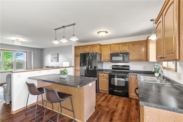 11684 44th Ave, Chippewa Falls, WI 54729 - kitchen with black appliances, a sink, dark countertops, and a kitchen bar