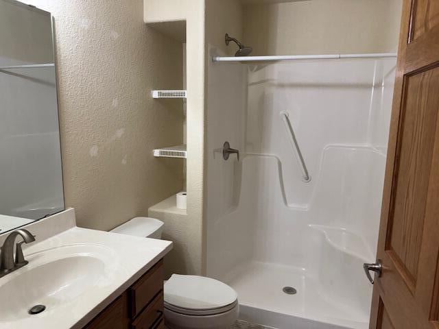 1329 S Wilson Ave, Hartford, WI 53027 - bathroom with a textured wall, a shower, toilet, and vanity