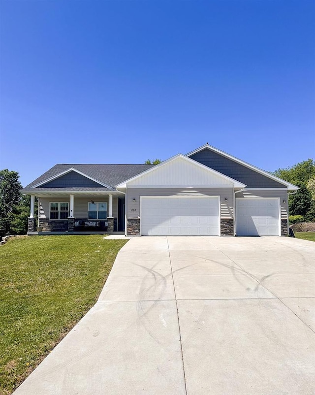 224 Clover Ln, Janesville, WI 53537 - view of front of home with stone siding, concrete driveway, an attached garage, and a front yard