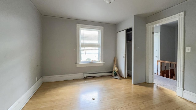 5410 N 37th St, Milwaukee, WI 53209 - unfurnished bedroom with a baseboard radiator, light wood-style floors, a closet, and baseboards