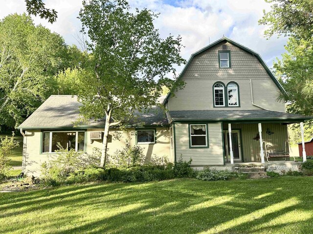 N2224 Wafle Rd, Mauston, WI 53948 - view of front of property featuring a front lawn, a gambrel roof, and a porch