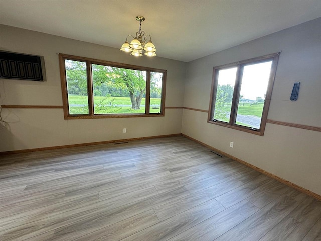N2224 Wafle Rd, Mauston, WI 53948 - unfurnished room featuring a chandelier, baseboards, and light wood-type flooring