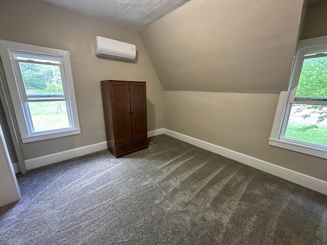 N2224 Wafle Rd, Mauston, WI 53948 - additional living space featuring a wall mounted air conditioner, vaulted ceiling, plenty of natural light, and baseboards