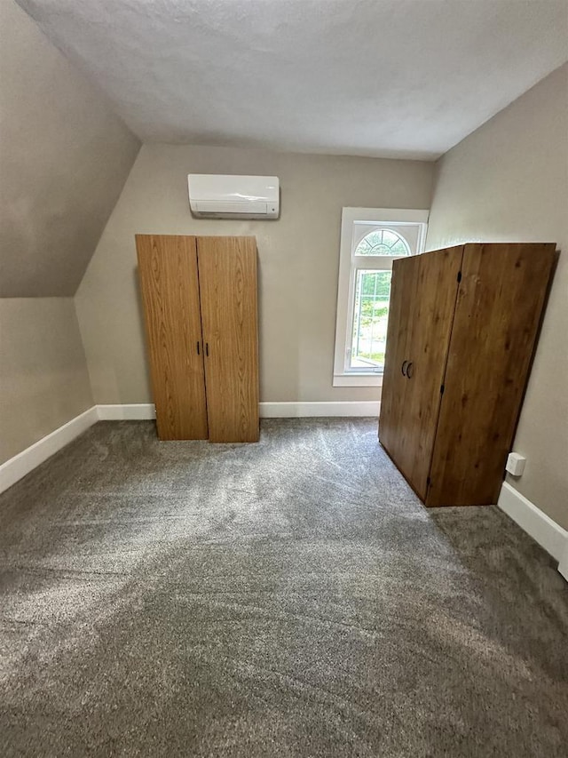 N2224 Wafle Rd, Mauston, WI 53948 - bonus room featuring an AC wall unit, baseboards, vaulted ceiling, and dark colored carpet