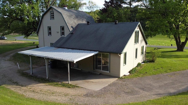 N2224 Wafle Rd, Mauston, WI 53948 - rear view of house with a lawn, roof with shingles, a chimney, and a carport