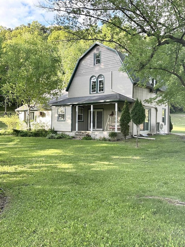 N2224 Wafle Rd, Mauston, WI 53948 - view of front facade with a gambrel roof, covered porch, and a front lawn