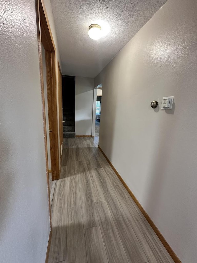N2224 Wafle Rd, Mauston, WI 53948 - hallway featuring a textured ceiling, wood finished floors, and baseboards