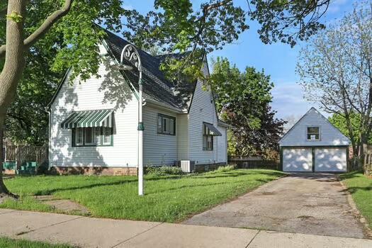 1107 Perry Ave, Racine, WI 53406 - view of side of property with a detached garage, an outbuilding, a lawn, and central air condition unit