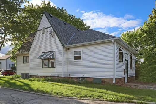 1107 Perry Ave, Racine, WI 53406 - view of side of property featuring a yard, central air condition unit, and roof with shingles
