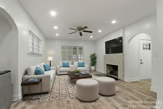 1107 Perry Ave, Racine, WI 53406 - living room featuring ceiling fan, wood finished floors, a fireplace, arched walkways, and recessed lighting