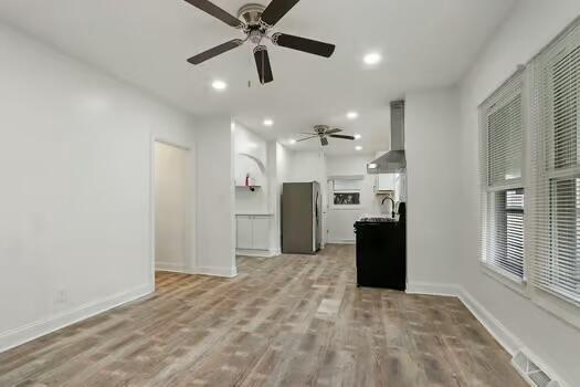 1107 Perry Ave, Racine, WI 53406 - unfurnished living room with a ceiling fan, baseboards, light wood-style floors, and recessed lighting