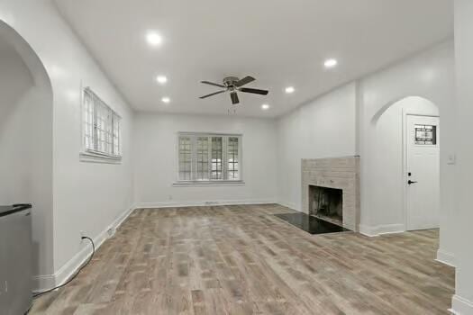 1107 Perry Ave, Racine, WI 53406 - unfurnished living room featuring ceiling fan, recessed lighting, arched walkways, a fireplace with flush hearth, and baseboards
